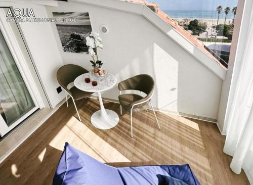 a small table and chairs in a room with a balcony at Amamare Luxury Room in Giulianova