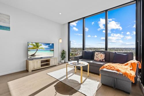 a living room with a couch and a tv at Skygarden On The Glen in Glen Waverley