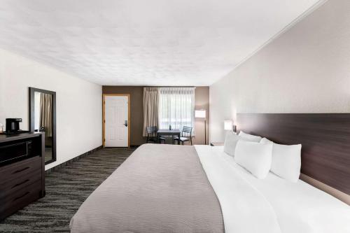 a hotel room with a large bed and a desk at Quality Inn & Suites Munising in Wetmore