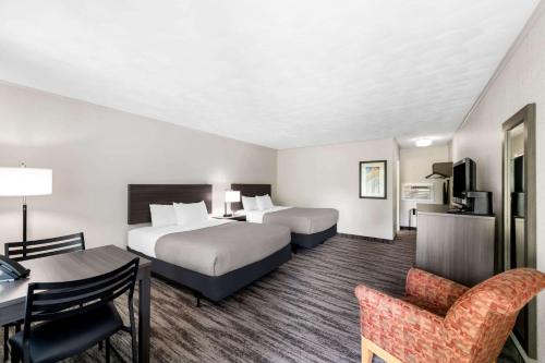 a hotel room with two beds and a desk at Quality Inn & Suites Munising in Wetmore