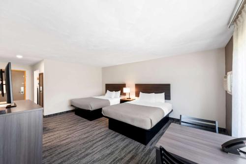a hotel room with two beds and a television at Quality Inn & Suites Munising in Wetmore