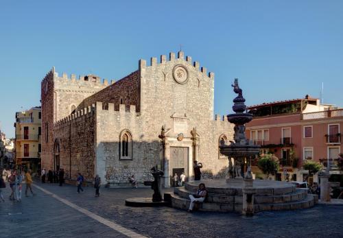 a large stone building with a fountain in front of it at Maison Blanche Taormina in Taormina