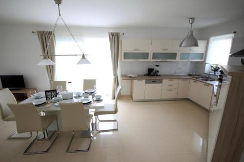 a kitchen and dining room with a table and chairs at Apartments Villa Mantinela in Malinska
