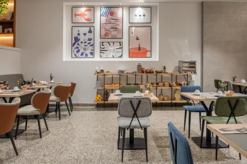 a restaurant with tables and chairs and a counter at Hotel Santiago Plaza Affiliated by Meliá in Santiago de Compostela