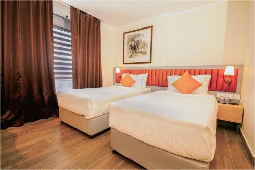 a hotel room with two beds and a window at The Grand Sona in Deoghar