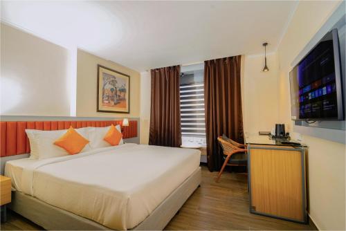 a hotel room with a bed and a television at The Grand Sona in Deoghar