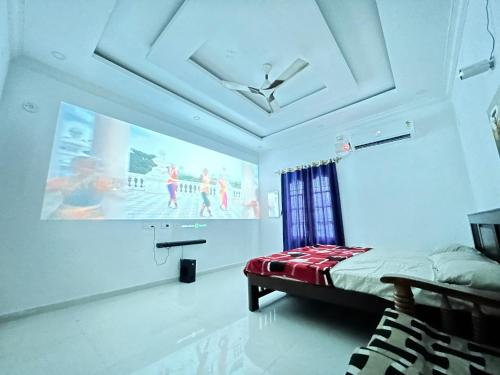 a room with a bed and a large screen at La Bay Luxury Beach Bungalow in Puducherry