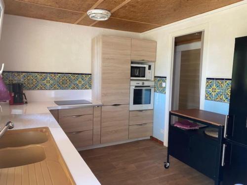 une cuisine avec un évier et une cuisinière four supérieur dans l'établissement Vaste appartement, jardin, proximité océan, à Capbreton