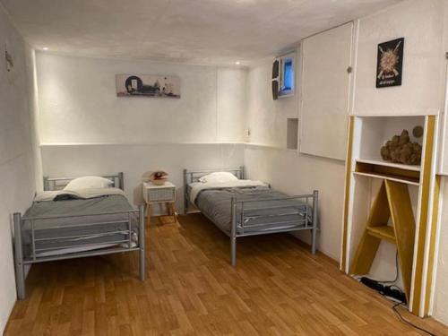 deux lits dans une chambre avec parquet dans l'établissement Vaste appartement, jardin, proximité océan, à Capbreton