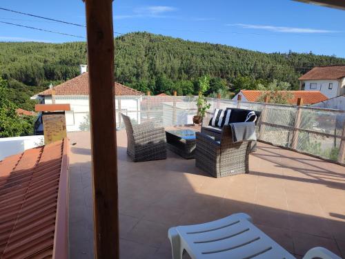a patio with two chairs and a table on a balcony at Casa Barroca in Figueiró dos Vinhos