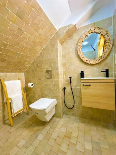 bagno con servizi igienici e specchio di Appartement luxe Perle Des Montagnes Chechaouen a Chefchaouen