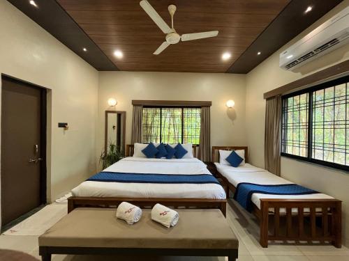a bedroom with two beds and a ceiling fan at Olive Resort & Villas in Khawāsa