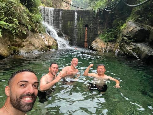 a group of men swimming in a waterfall at Family Hotel Zhangjiajie in Zhangjiajie
