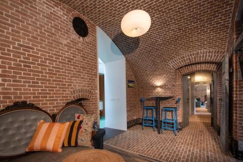 a room with a brick wall with a bed and chairs at Fort Vuren in Vuren