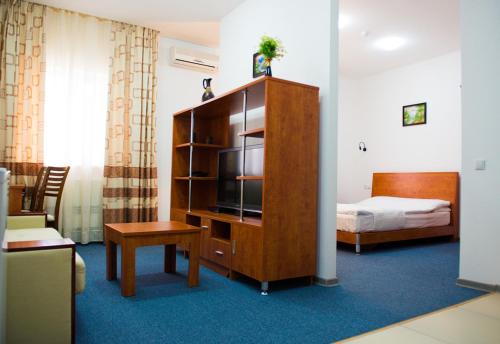 a hotel room with a television and a bed at Residence Keruen in Atyrau