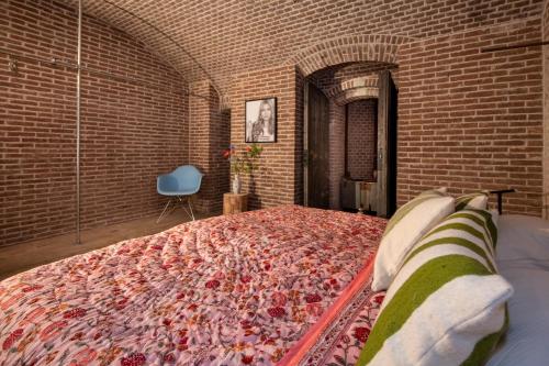 a bedroom with a large bed in a brick wall at Fort Vuren in Vuren