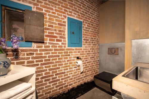 a bathroom with a brick wall with a blue door at Fort Vuren in Vuren