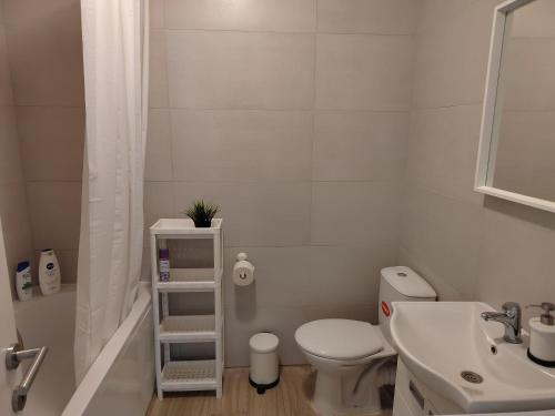 a white bathroom with a toilet and a sink at Lovely one bedroom apartment in Ub