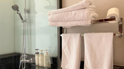 a bathroom with white towels on a rack and a mirror at 嵩山居-丽晶精品民宿 in Dengfeng