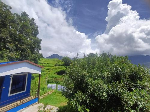 a blue house with a view of a field at Lake Haven Resort, Sari, Chopta in Sari