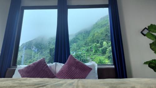 a bedroom with a large window with a mountain view at Lake Haven Resort, Sari, Chopta in Sari