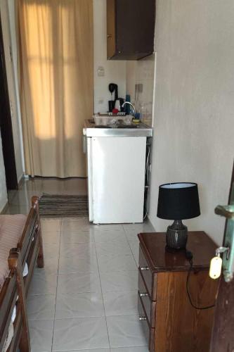 a kitchen with a refrigerator and a table with a lamp at Chliara apartments by Tzalas in Skala Eresou