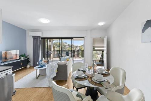 a living room with a table and chairs at modern apartment in the heart of Norman Park in Brisbane