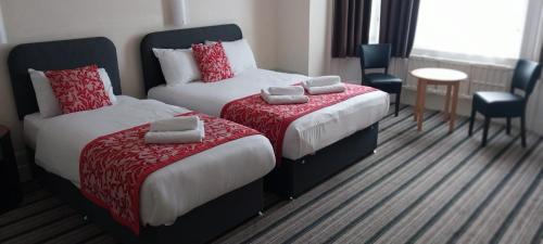 a hotel room with two beds and a table and chairs at Heathlands Hotel in Bournemouth