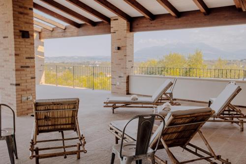 a patio with chairs and a table and a balcony at Agriturismo L'Elisir di Atena in Moscufo