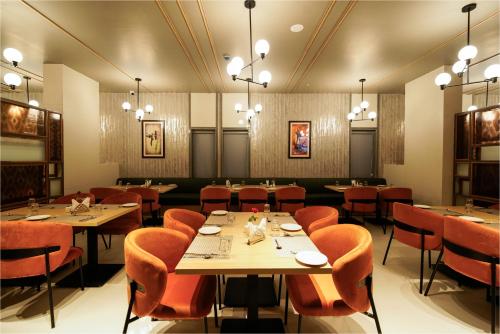 a dining room with tables and chairs and chandeliers at The Grand Sona in Deoghar