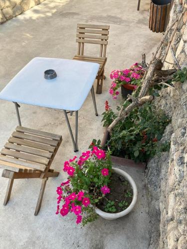 a table and a chair and some flowers and a bench at New Home in Chişinău