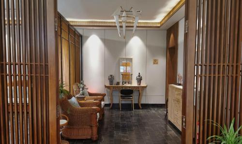 a hallway with chairs and a table in a room at 嵩山居-丽晶精品民宿 in Dengfeng