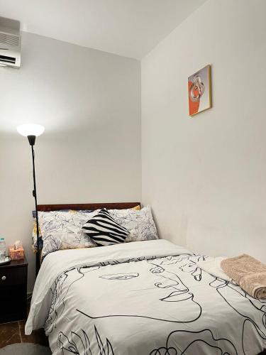 a bedroom with a bed with a black and white comforter at Tanih's Lodging in Abu Dhabi