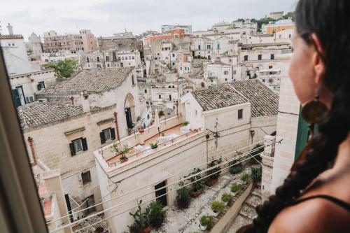 a woman looking out of a window at a city at La Casa di Ele in Matera
