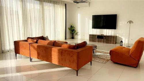 a living room with a couch and a flat screen tv at Ixora AP 2 in Ngor