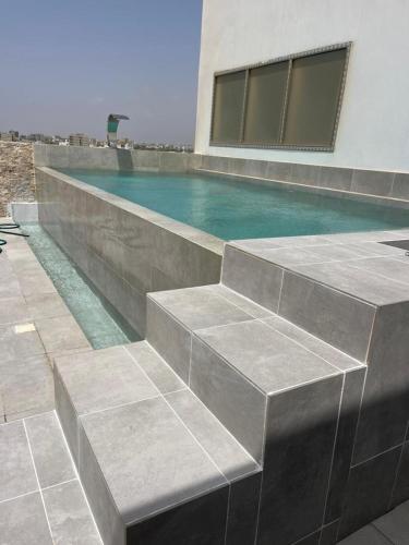 a swimming pool with blue water next to a building at Ixora AP 2 in Ngor