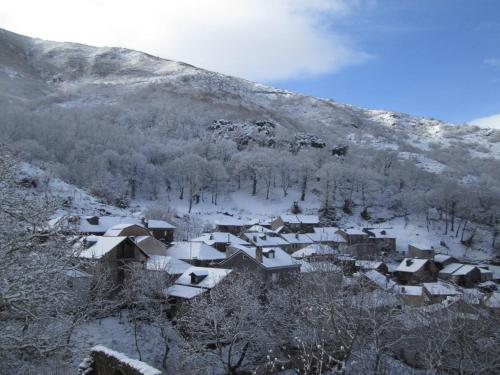 a village covered in snow in front of a mountain at CASA BORAL- Comfort exclusivo en plena naturaleza - Valle del Silencio in Manzanedo de Valdueza