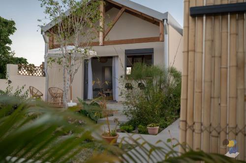 a house with a garden in front of it at L'oasis 3 étoiles - Lodge 2 - DODOTERLA in Le Tampon