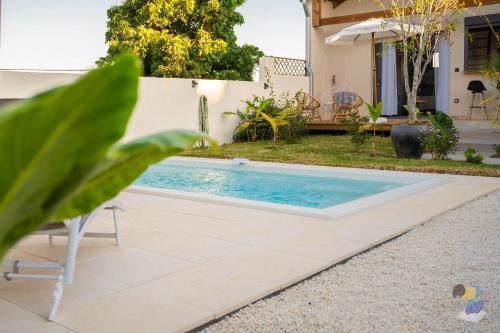 a swimming pool in the backyard of a house at L'oasis 3 étoiles - Lodge 2 - DODOTERLA in Le Tampon