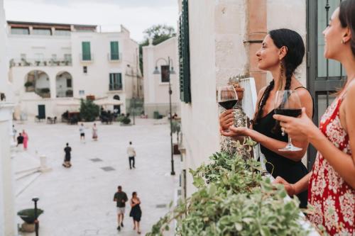two women standing outside a window drinking wine at La Casa di Ele in Matera