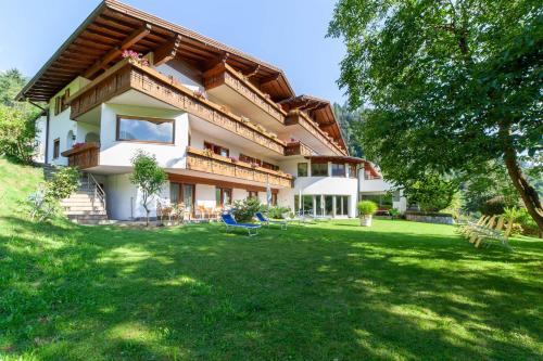 a large house with a green lawn in front of it at Hotel St. Pankraz in San Pancrazio dʼUltimo