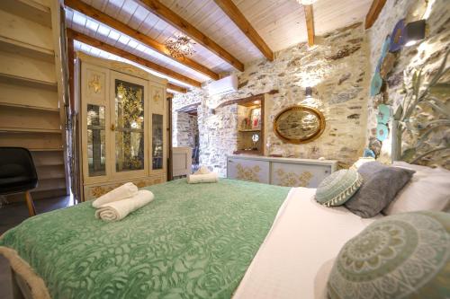 a bedroom with a large bed in a stone wall at RODIBLUE VILLAGE Apartments in Rodia
