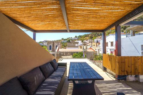 a porch with a bench and a wooden roof at RODIBLUE VILLAGE Apartments in Rodia