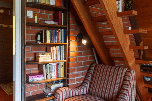 a book shelf filled with books next to a couch at Pet-Friendly - Planinska Vikendica Međurečje in Ivanjica