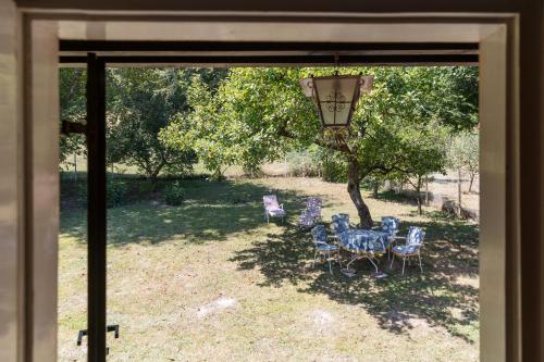 a table and chairs sitting under a tree in a yard at Pet-Friendly - Planinska Vikendica Međurečje in Ivanjica