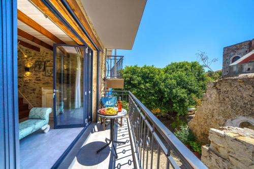 a balcony with a table with a bowl of fruit on it at RODIBLUE VILLAGE Apartments in Rodia