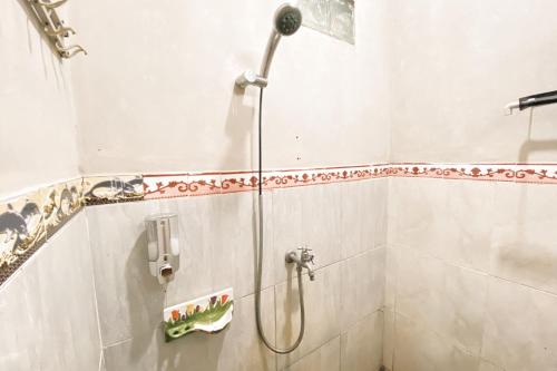 una ducha con cabezal de ducha en un baño en Central House Karimunjawa Mitra RedDoorz, en Karimunjawa