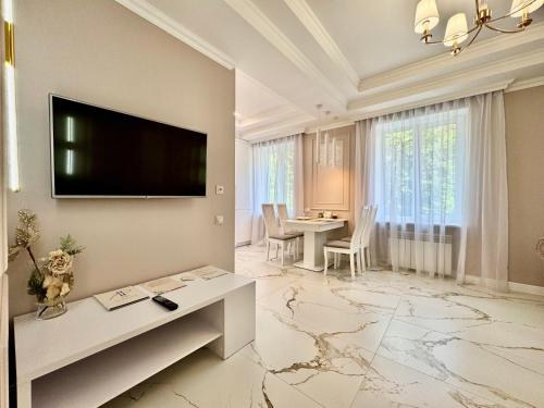 un soggiorno con una TV a schermo piatto su una parete di ApartPoltava NEW PALACE 2023 Вишукані апартаменти на Соборності Центр Готельні чеки a Poltava