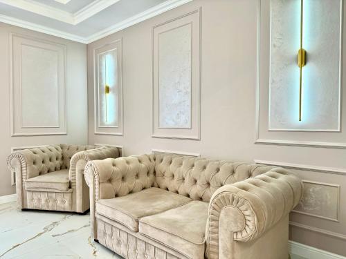un soggiorno con due divani trapuntati di ApartPoltava NEW PALACE 2023 Вишукані апартаменти на Соборності Центр Готельні чеки a Poltava
