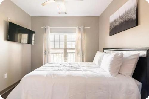 a bedroom with a large white bed with a window at Uptown Stay and Adventures with Pool, Bars & Shops in Charlotte